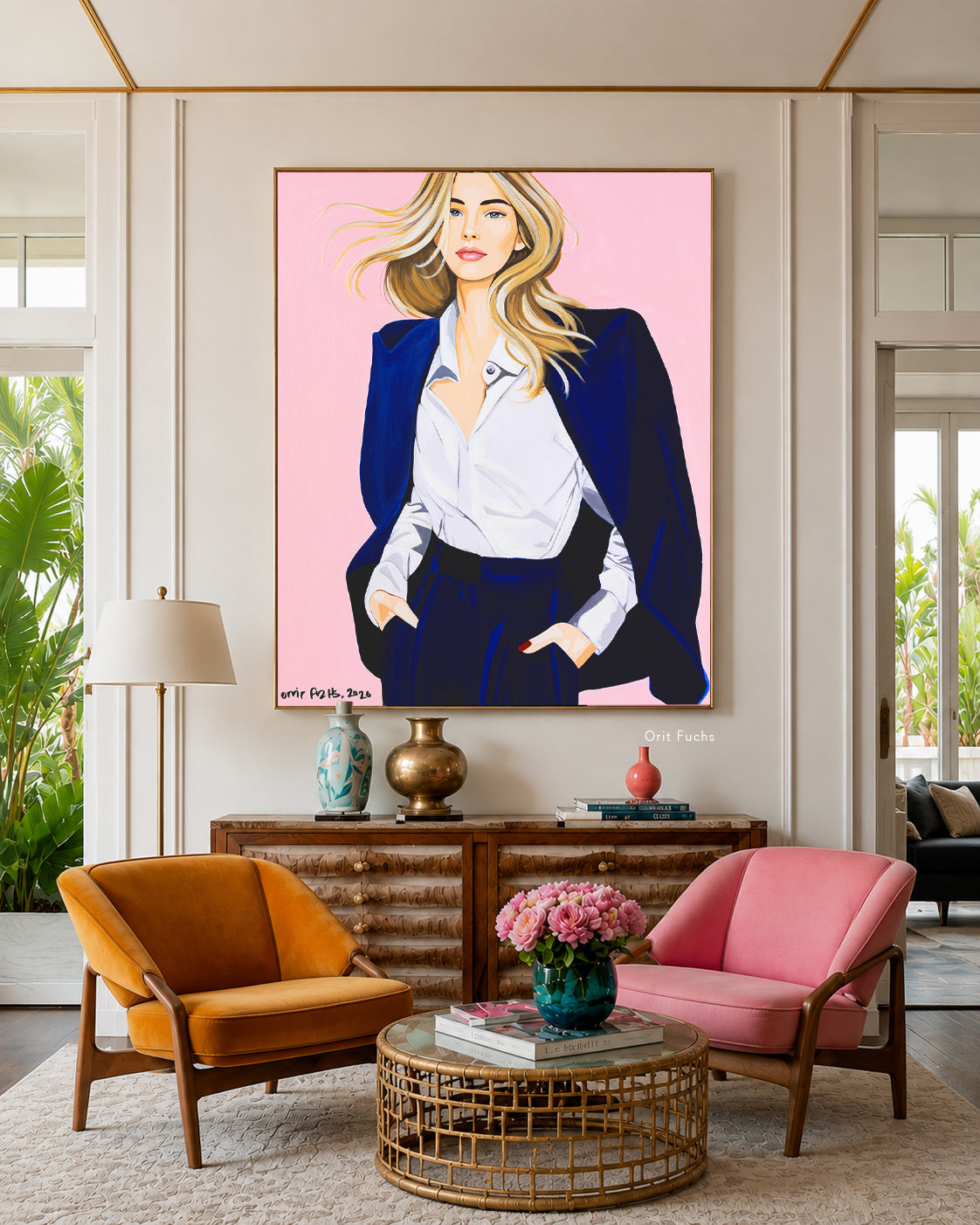 A large framed art print featuring a stylized portrait of a woman with blonde hair, wearing a white shirt and dark blazer against a pink background, displayed on a wall in a modern living room setting above a wooden console table.